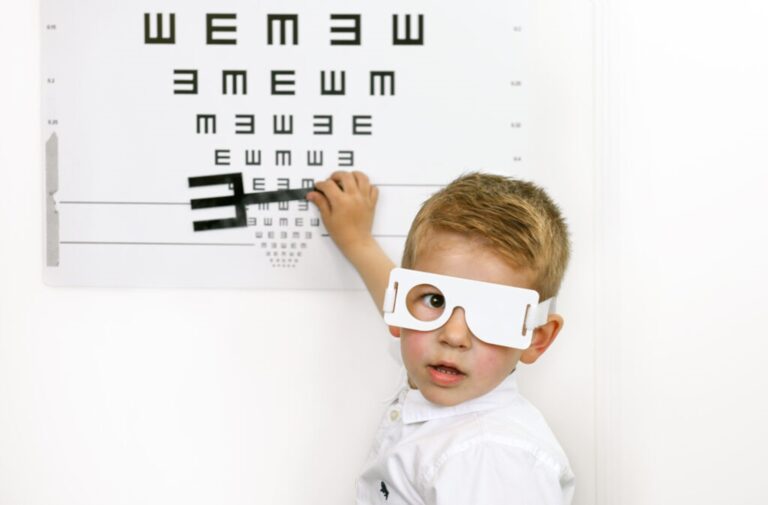Een jongen doet de oogtest met E-haak op het consultatiebureau