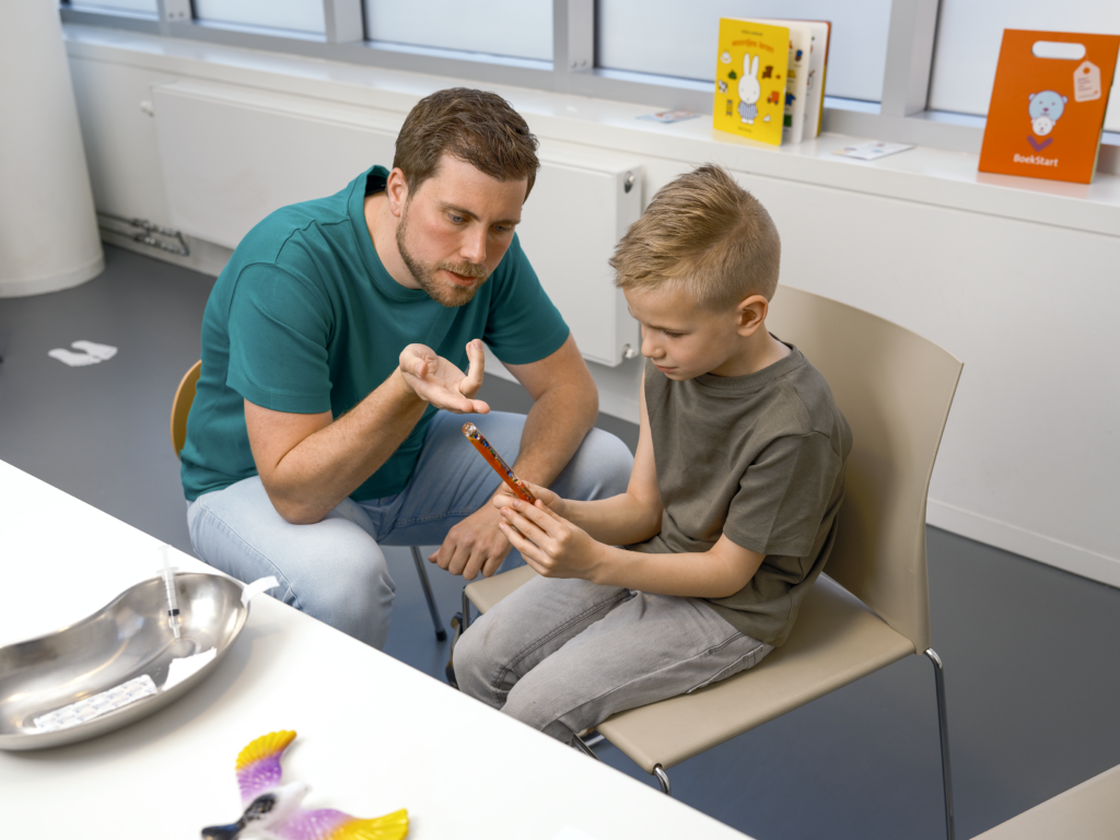 Een jongen en een jeugdverpleegkundige op het consultatiebureau